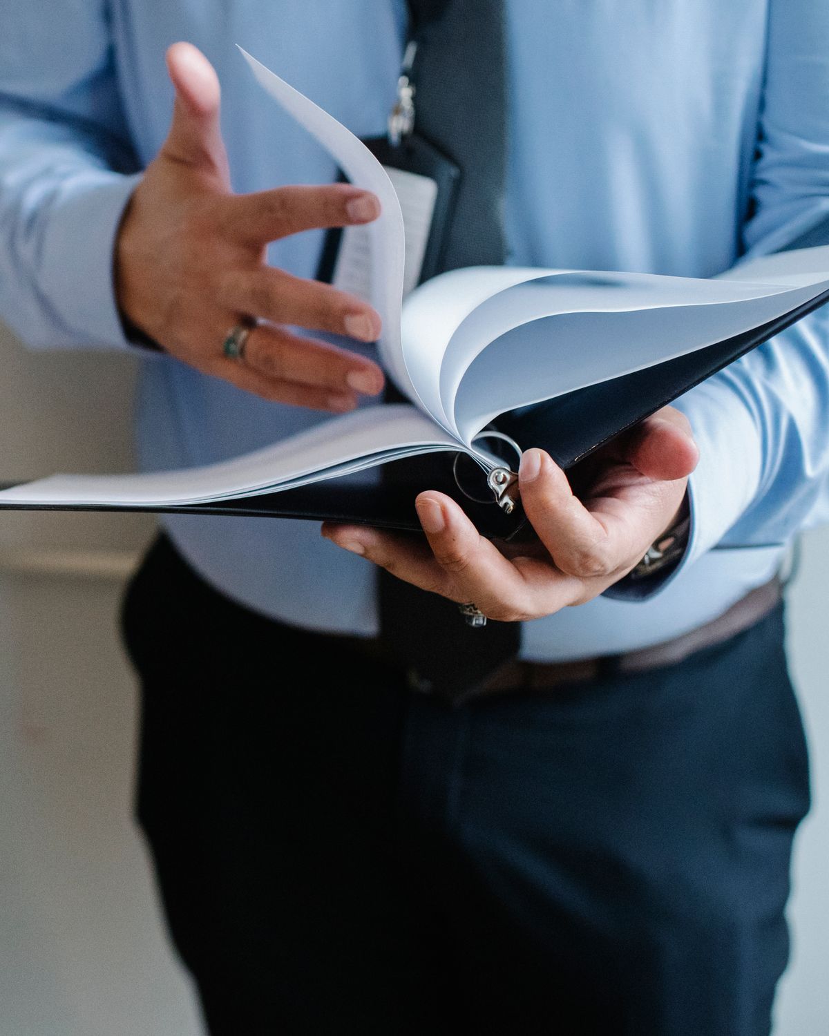 Professional leafing through a bound corporate intelligence dossier