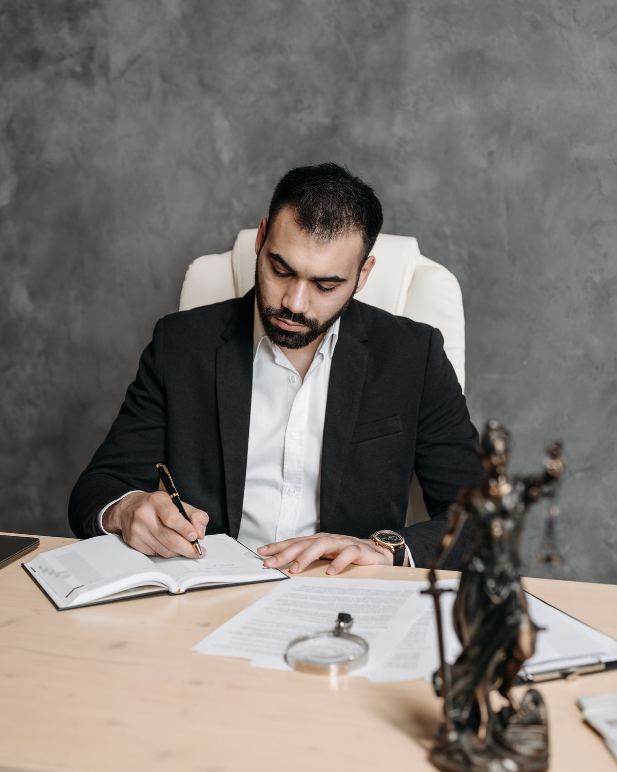 Lawyer reviewing legal documents and case papers at an office desk